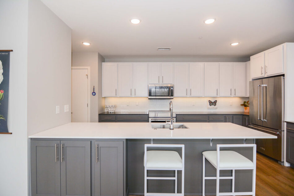 Kitchen with two-toned cabinets and seating at counter.
