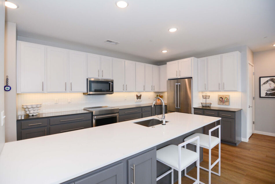 Kitchen with two-toned white and gray cabinets.