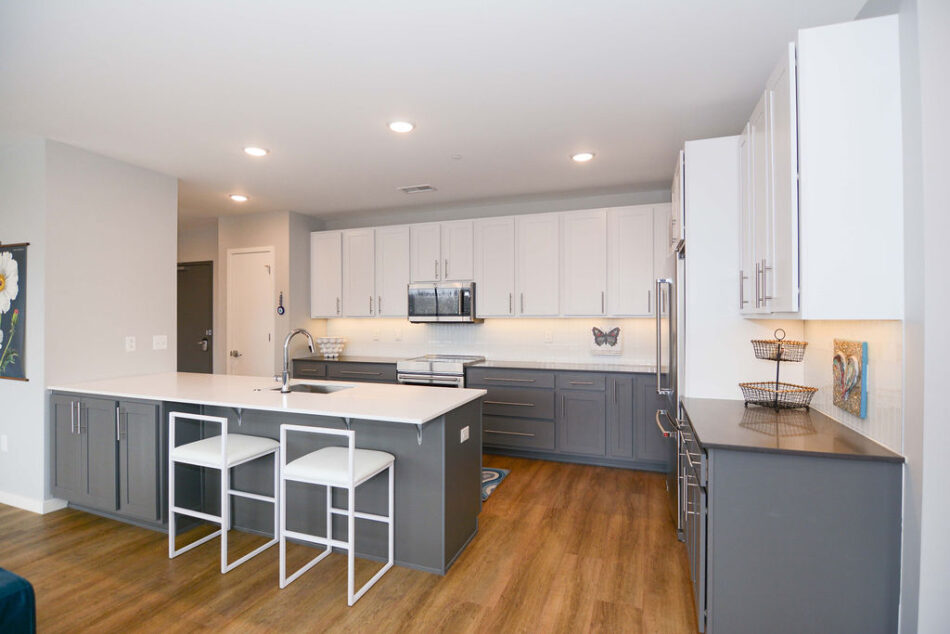 Kitchen with large counter and sink facing living room.