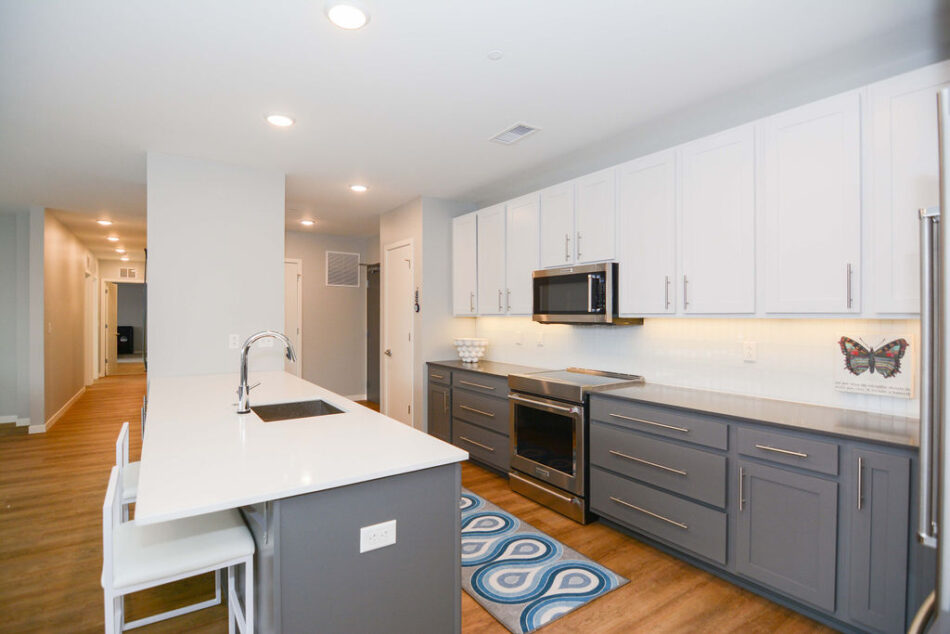 Kitchen with stainless steel microwave above stove.