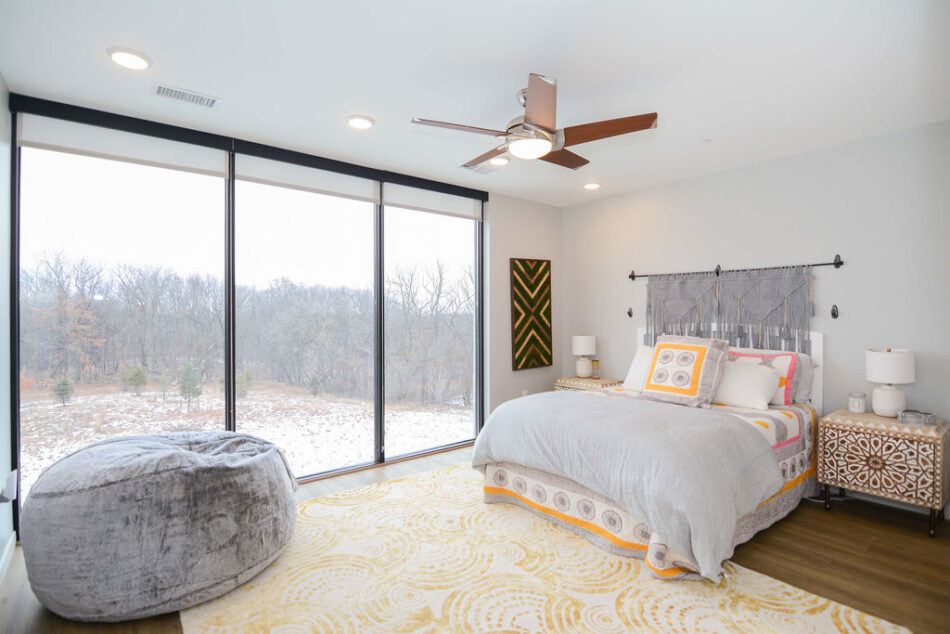 Bedroom with a wall of floor-to-ceiling windows.