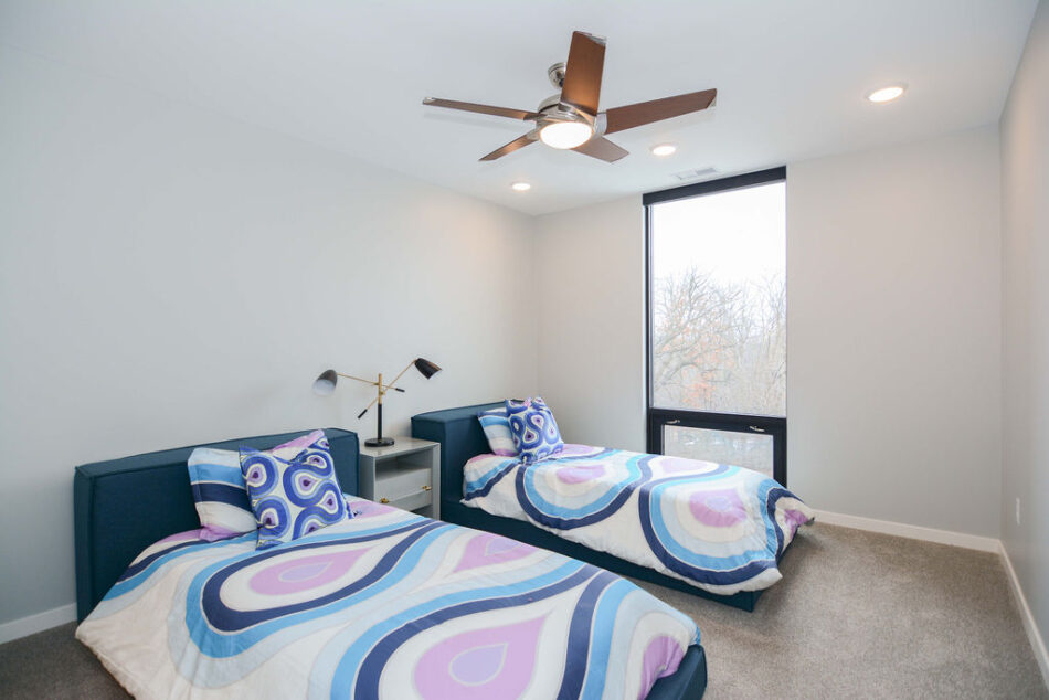 Bedroom with floor-to-ceiling window and inset ceiling lights.