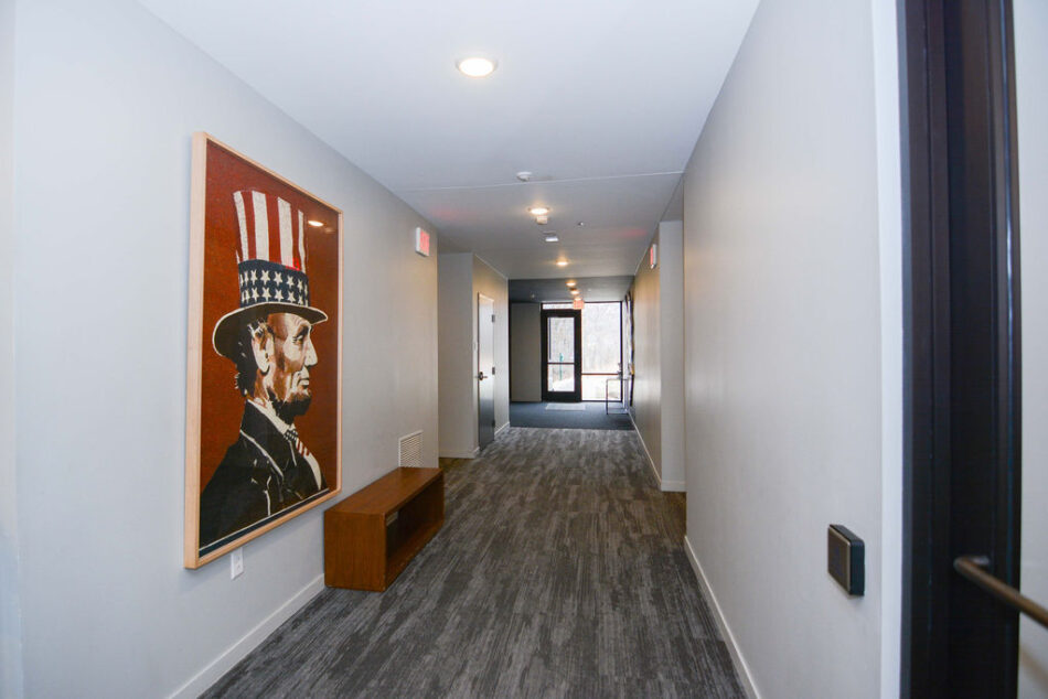Hallway with gray carpet inside condo building.