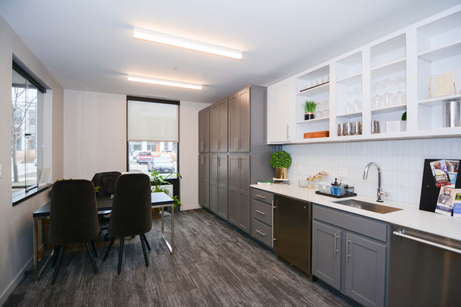 Condo community room with sitting area, sink, and cabinets.
