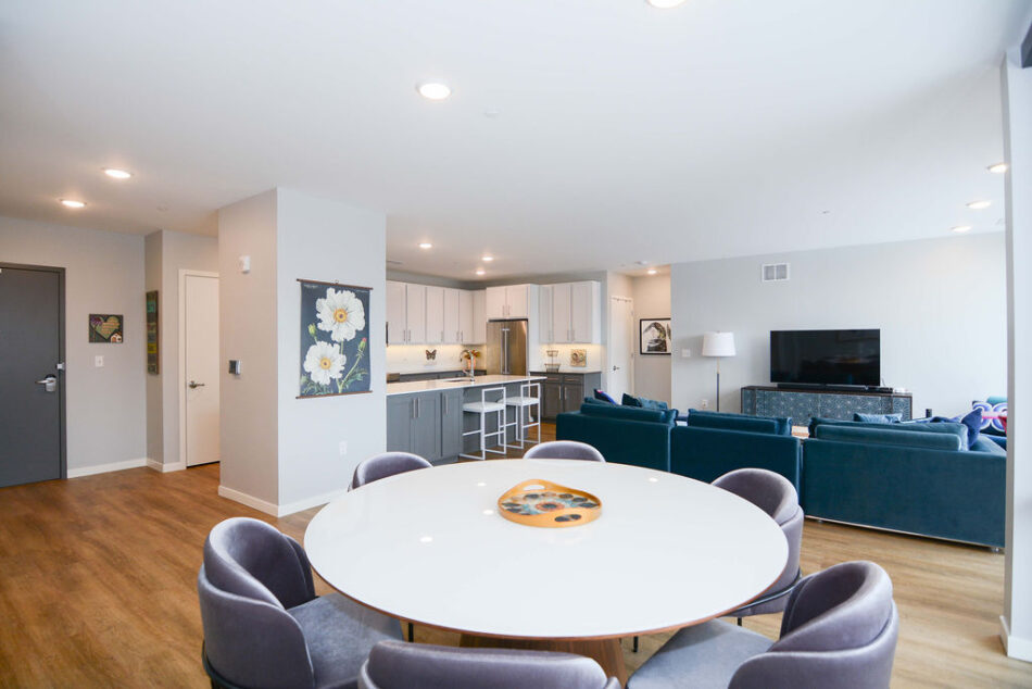 Living area with dining nook, sitting room, and kitchen beyond.