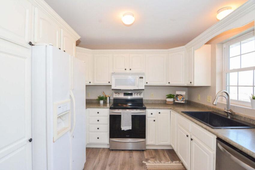 Kitchen with stainless steel oven and white microwave.
