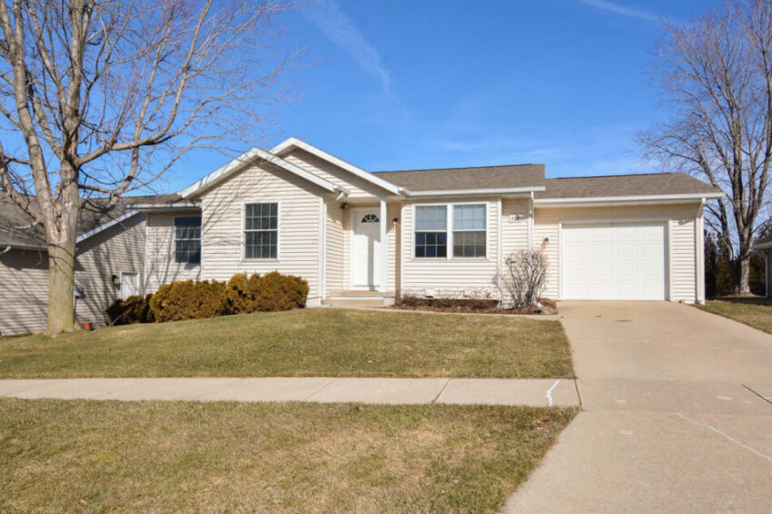 Exterior of beige two-story home with attached one-car garage.