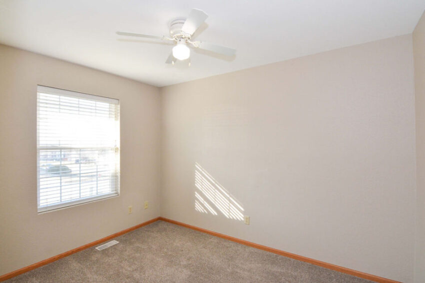 Bedroom with window and ceiling fan.