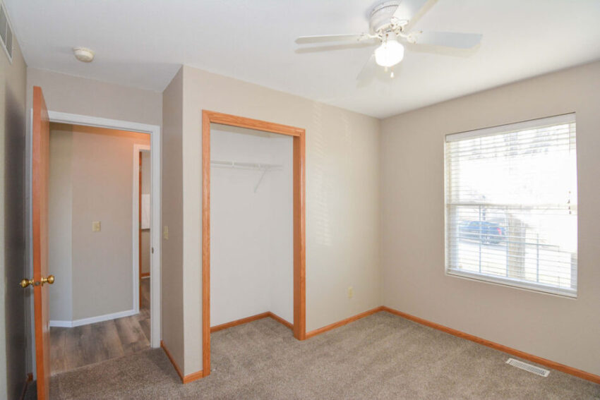Bedroom with large window and open closet.