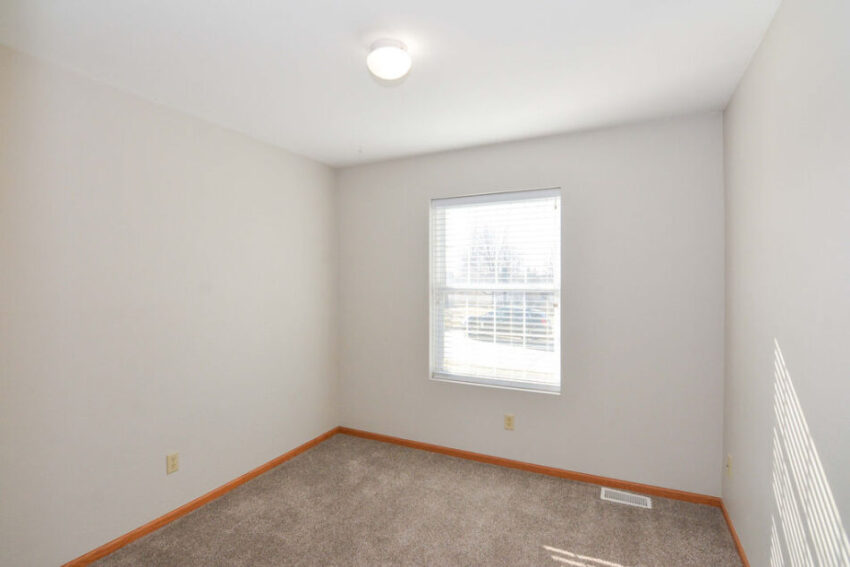 Bedroom with gray carpet and overhead light.
