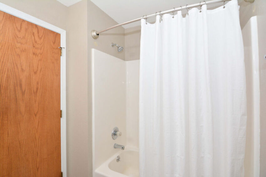 Bathroom with tub/shower combo and shower curtain.