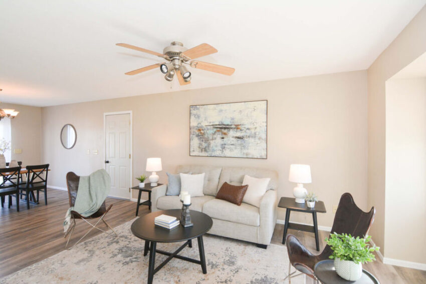 Living room with ceiling fan and wood-like LVP flooring.