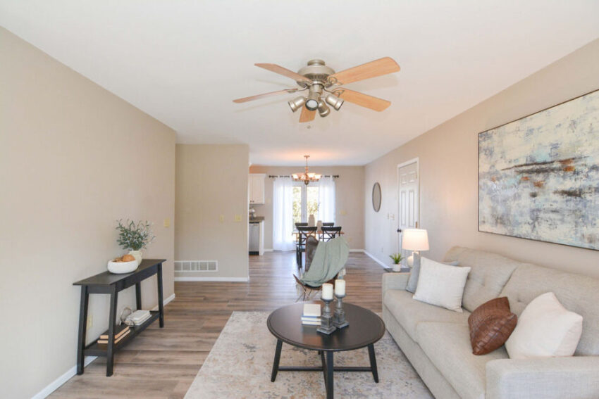 Cozy living room with ceiling fan and beige walls.