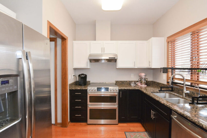 Kitchen with white cabinets and stainless steel appliance.