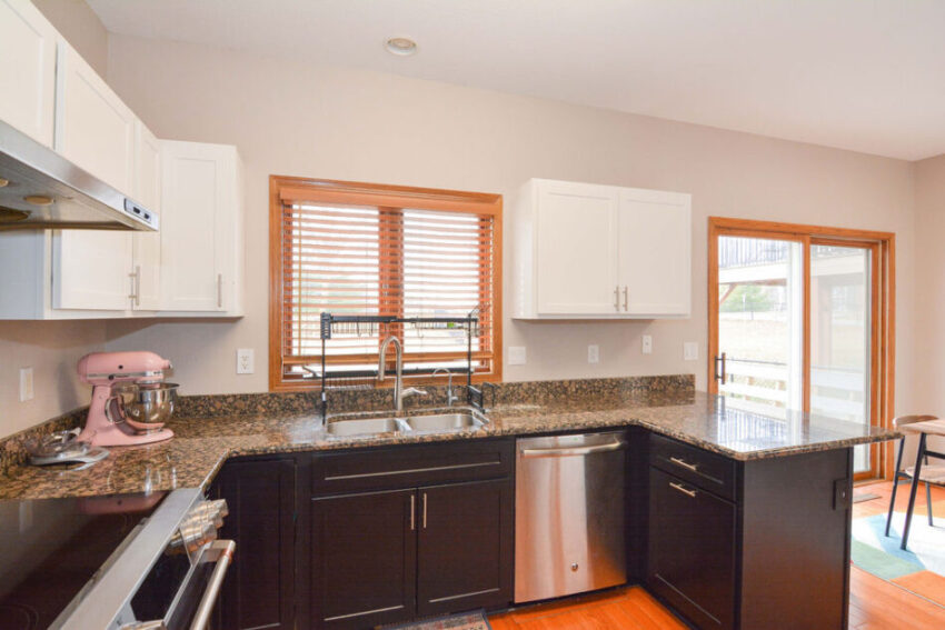 Kitchen with oak floors and two-tone black and white cabinets.