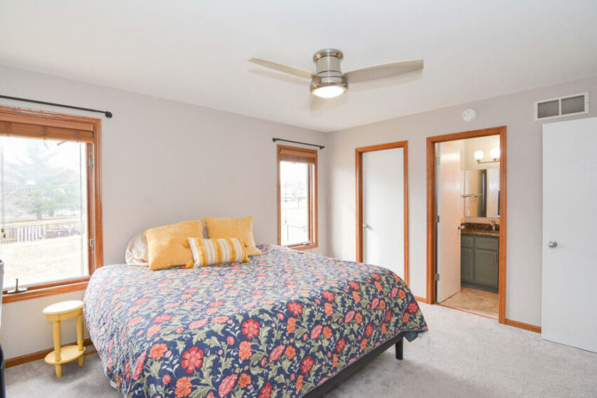Bedroom with large windows and ensuite bathroom.