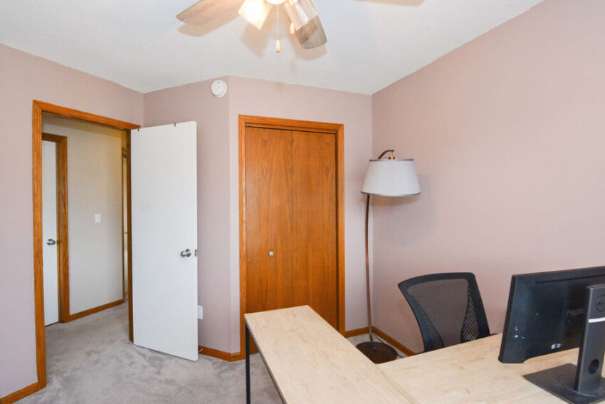 Office with beige carpet and rose-colored walls.