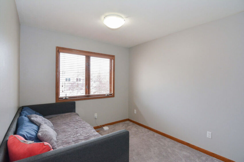 Bedroom with carpet and overhead light fixture.