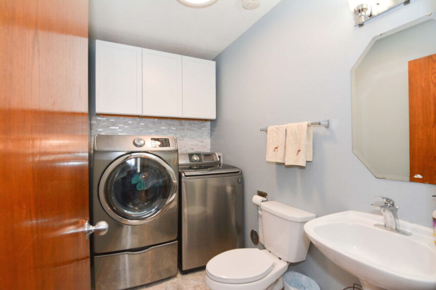 Bathroom with stainless steel washer and dryer.