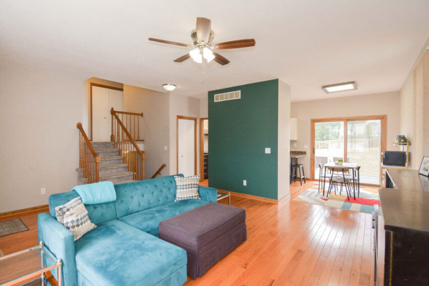 Large living room with shining floors and dining room beyond.