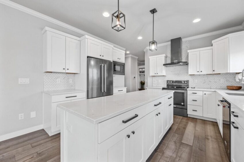 Large kitchen with white cabinets and island with storage.