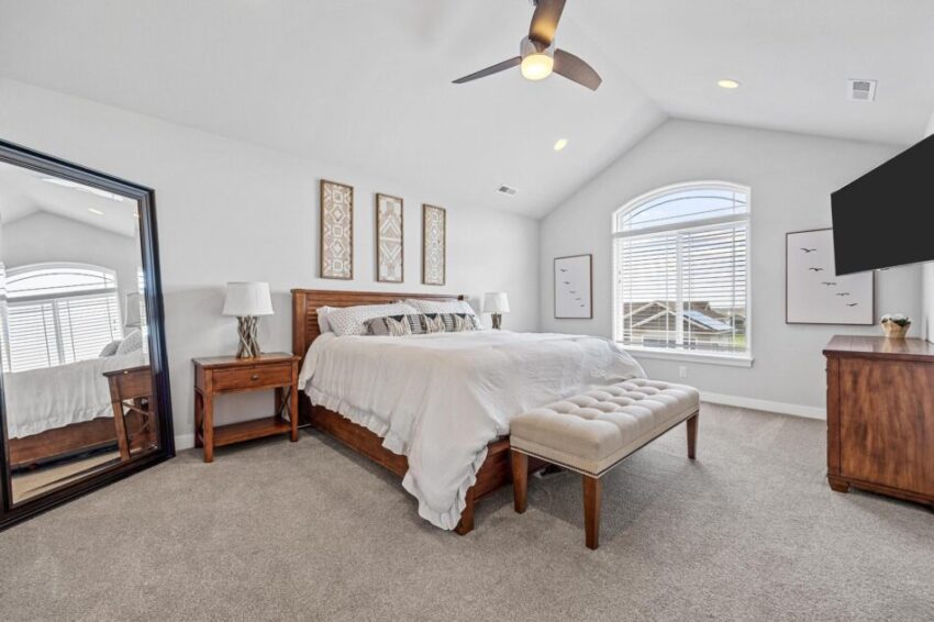 Bedroom with peaked ceiling and beige carpet.