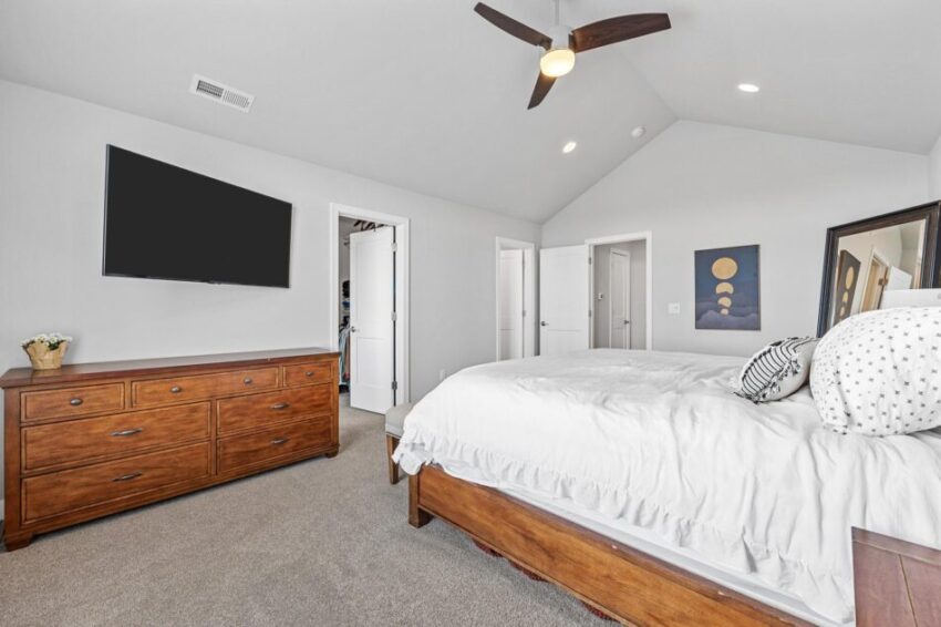 Bedroom with ceiling and wall--mounted television.