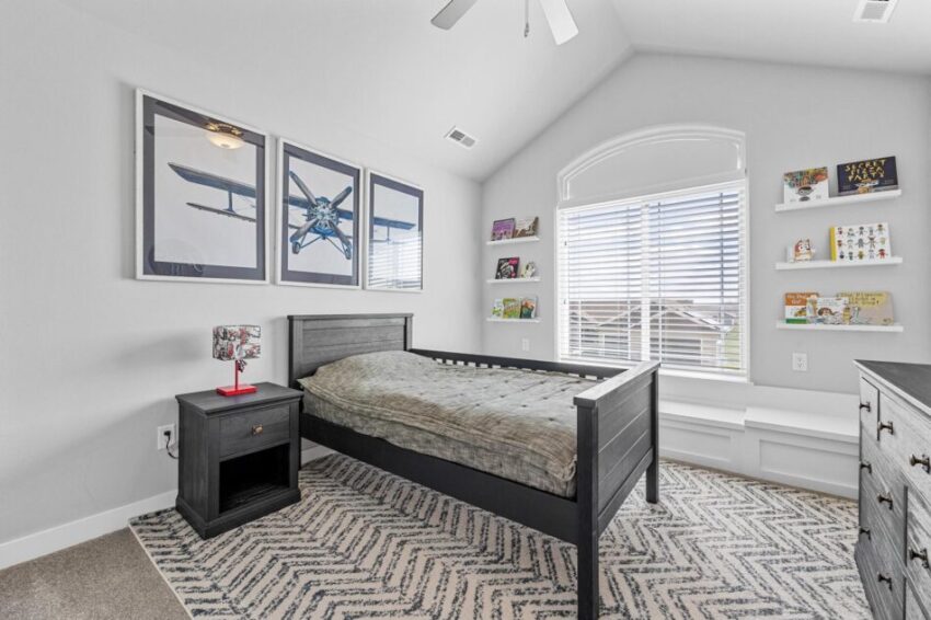 Bedroom with peaked roof and arched window.