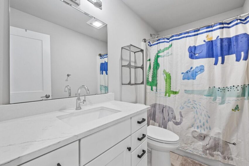 Bathroom with white countertops and large mirror.