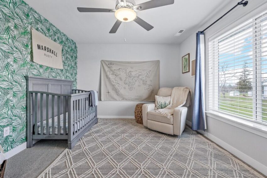 Bedroom with large window and ceiling fan.