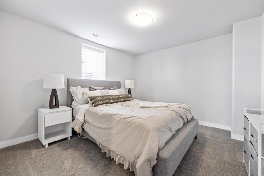 Bedroom with white walls and gray carpet.