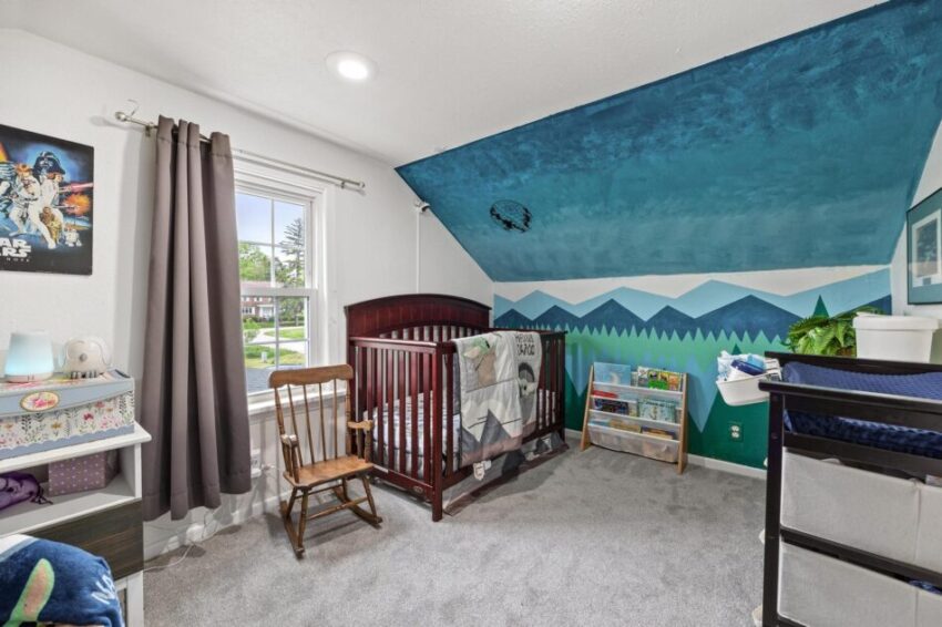 Bedroom with wall mural and crib.