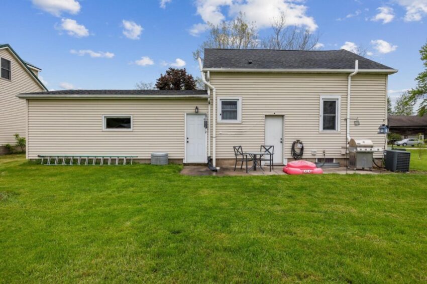 Back of house with yard and patio.