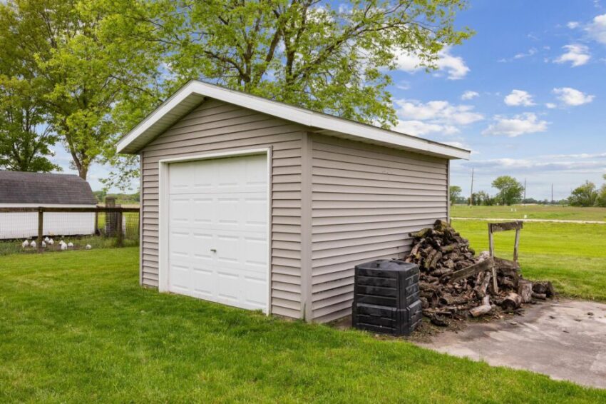 Beige shed with large door.