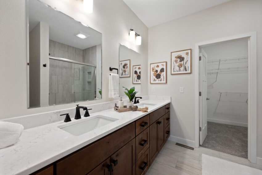 Bathroom with black faucet and large mirror.