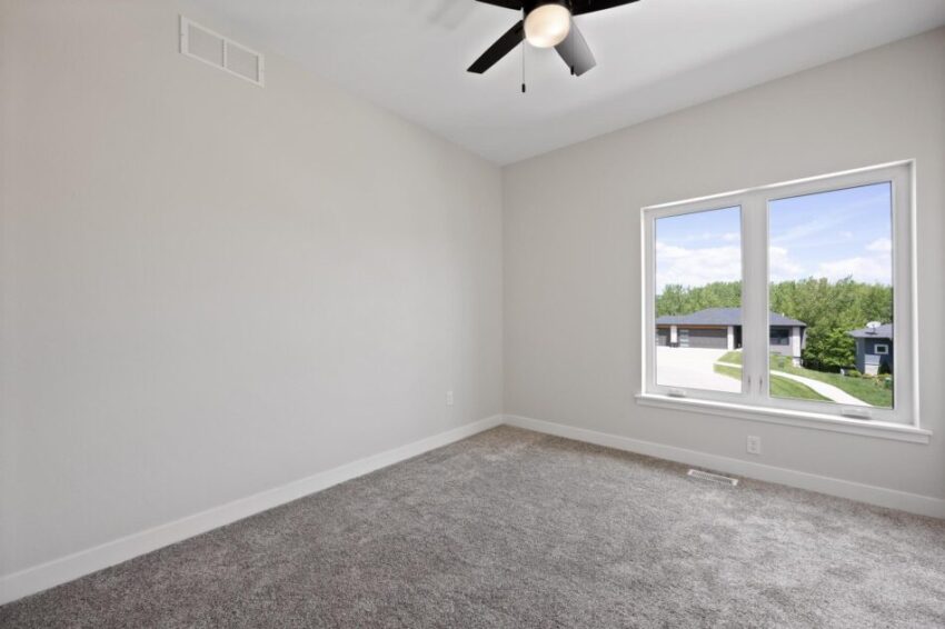 Bedroom with gray carpet and windows.
