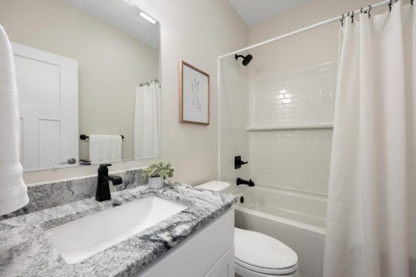 Bathroom with black fixtures and tub/shower combo.