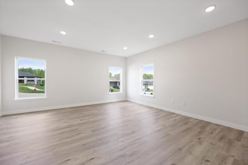 Large room with LVP flooring and beige walls.