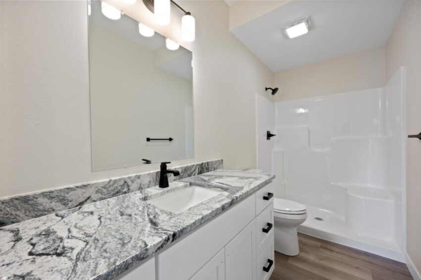 Bathroom with shower and black fixtures.