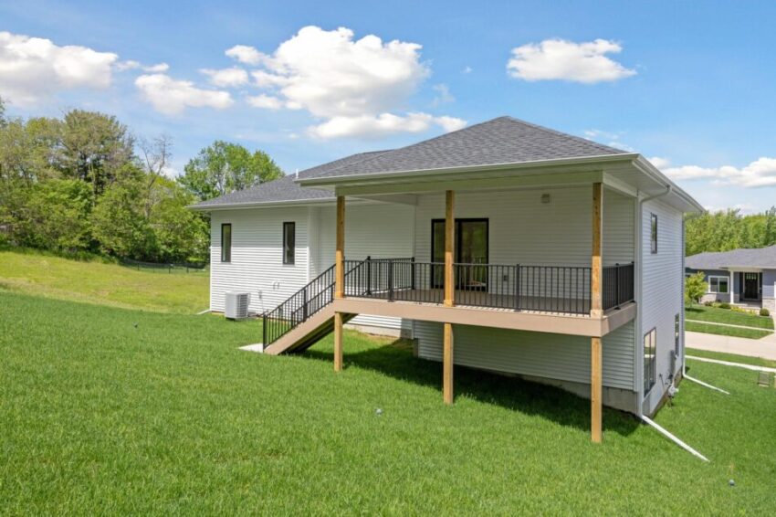 Exterior of house with spacious back yard and deck.