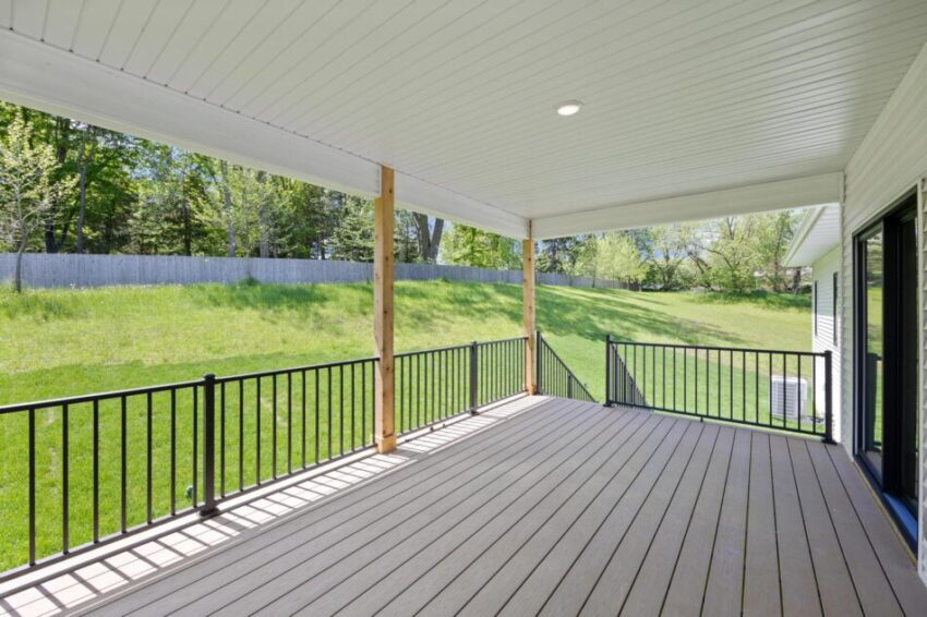 Deck with black railing and expansive lawn.