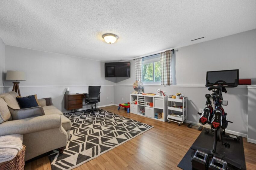 Den with mounted television.