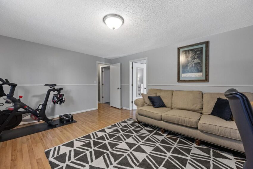Workout room with couch and stationary bike.