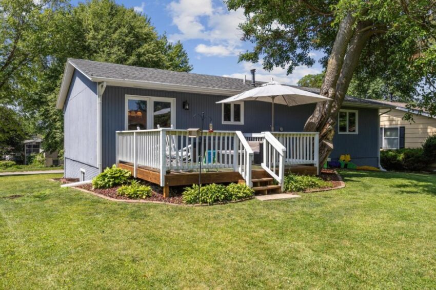 Blue house with cute deck and umbrella.