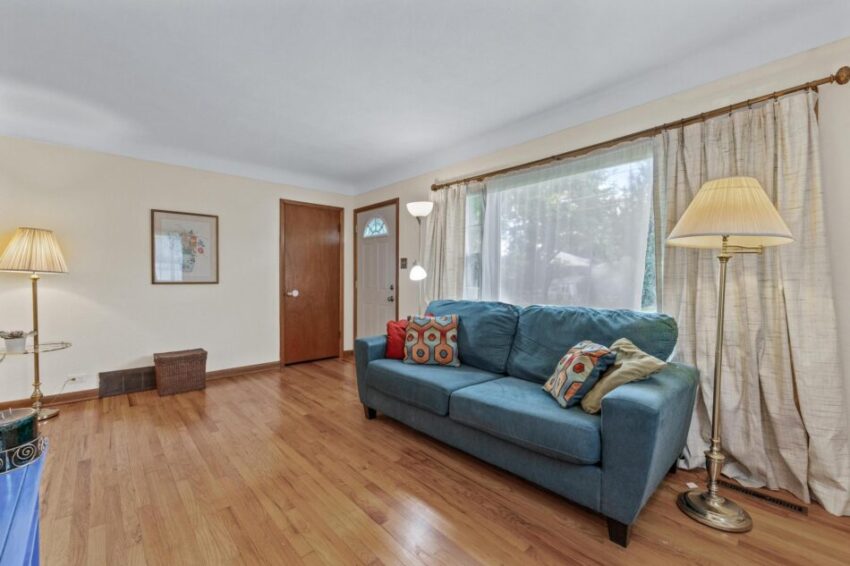 Living room with large picture-window and cream-colored walls.