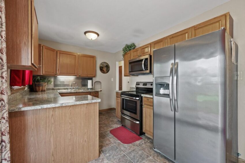 Kitchen with updated floors, overhead light fixture, and light above sink.