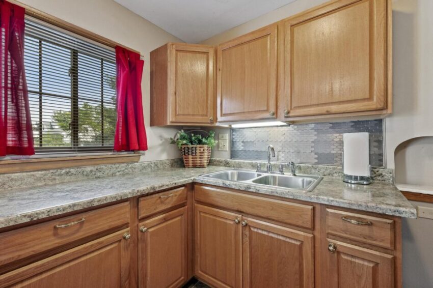 Kitchen with backsplash and window above counter.