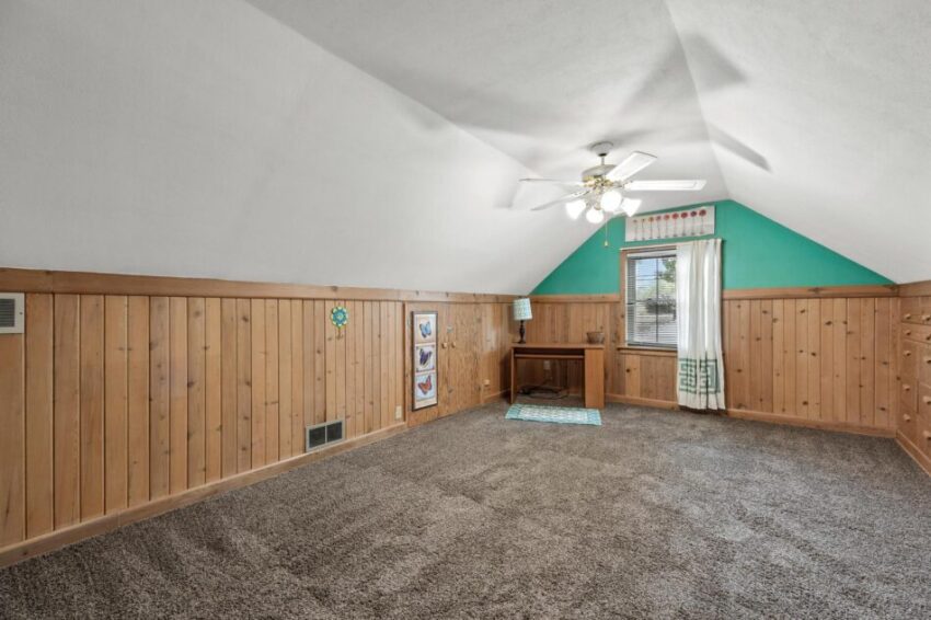 Bonus room with sloped ceiling and ceiling fan.