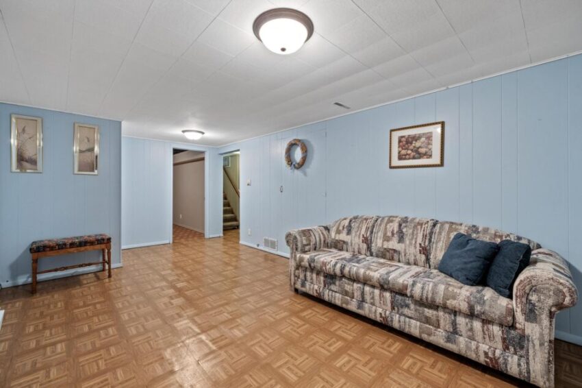 Finished lower level with white ceiling and light fixture.