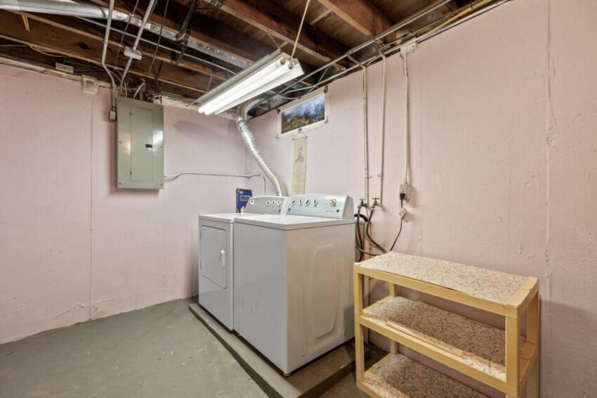 Utility area with washer, dryer, and fuse box.